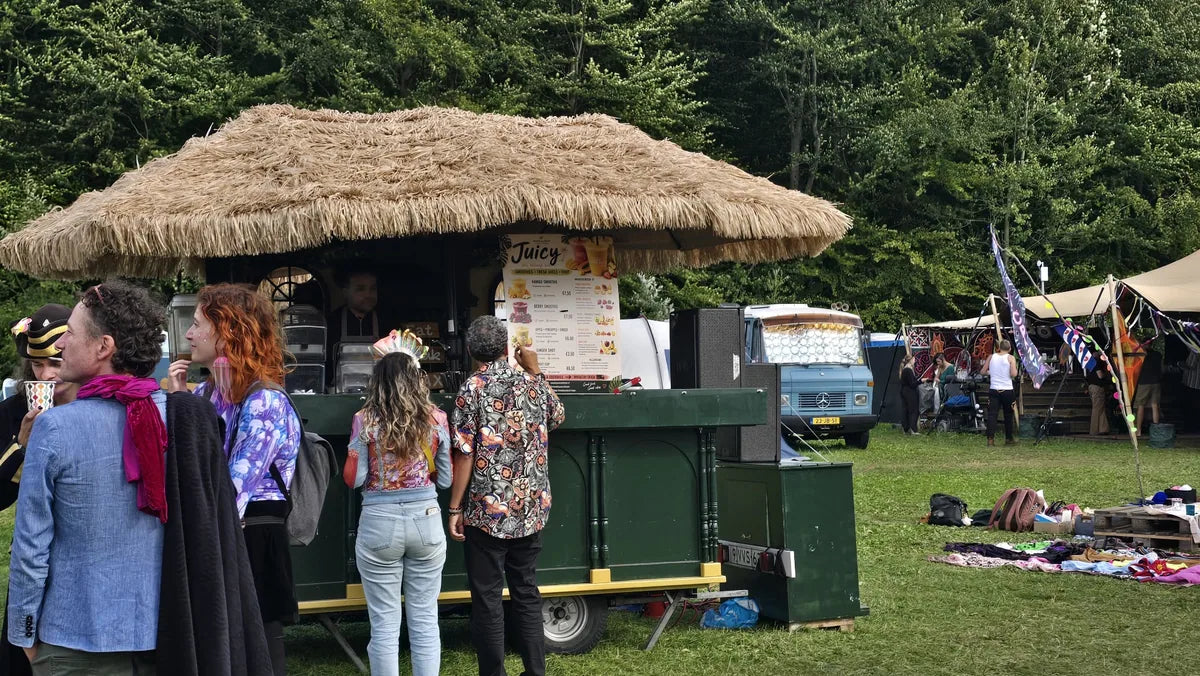Tropische juicebar met rieten dak en een smoothiekaart op een buitenevenement